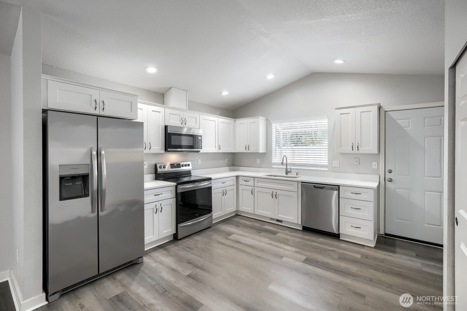 1607 Springfield Court Northeast Olympia, WA 98506 - Photo 6 of 21 a large kitchen with cabinets stainless steel appliances and wooden floor