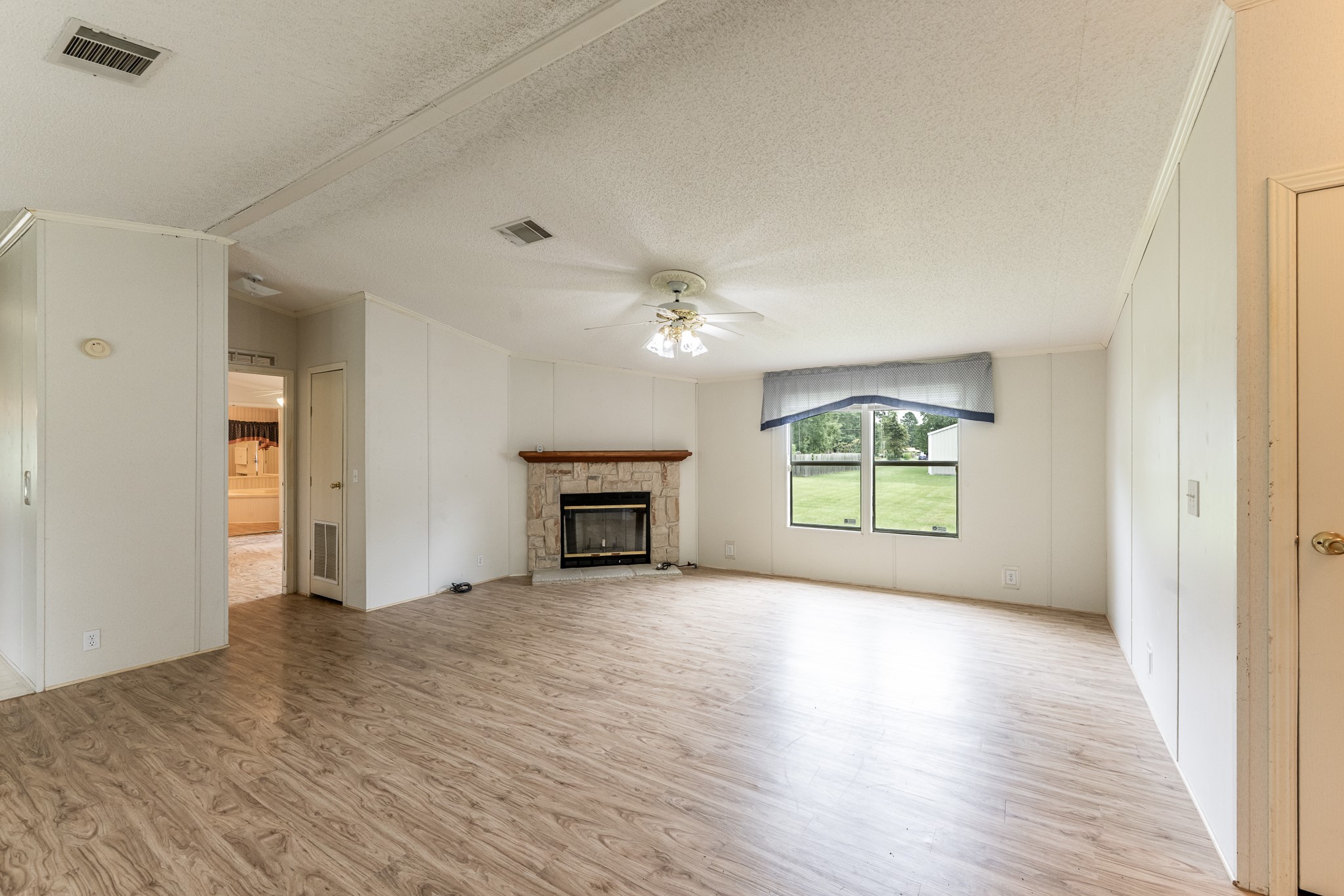 227 Cutter Drive Trinity, TX 75862 - Photo 8 of 39 a view of an empty room with a window and wooden floor
