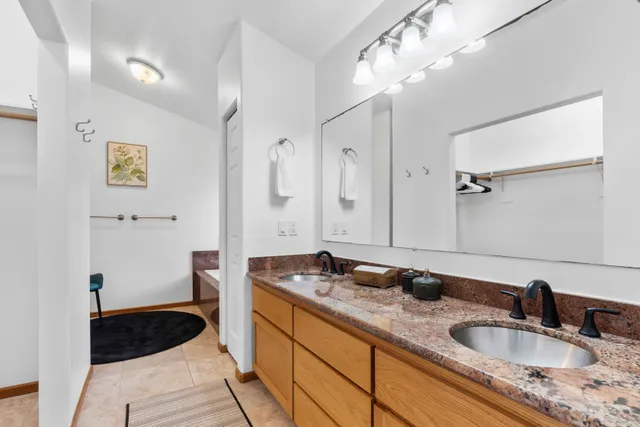 a bathroom with a granite countertop sink a toilet a shower and a mirror