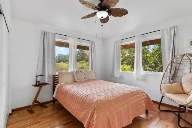 a bedroom with a bed chandelier and a window