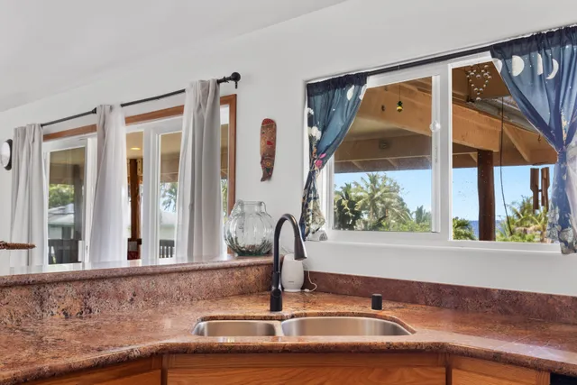 a bathroom with a sink and a large mirror next to a window