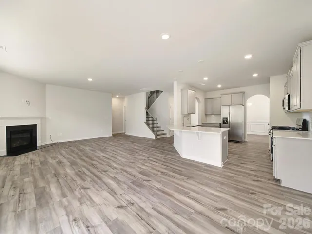 a view of an empty room with a window and chandelier