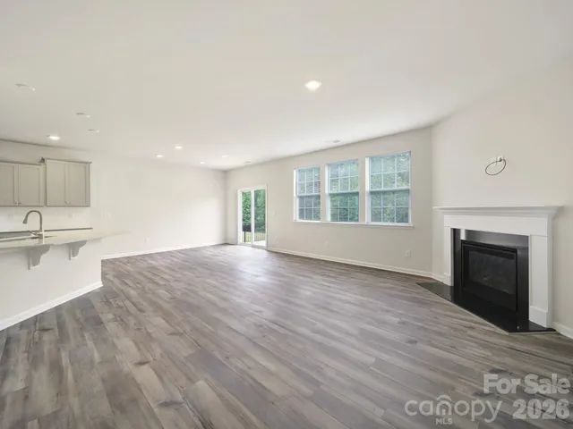 a view of empty room with wooden floor and fireplace