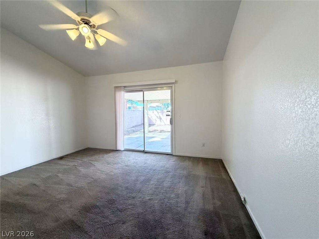 8620 Magnolia Ridge Avenue Las Vegas, NV 89134 - Photo 9 of 15 A spacious room with a vaulted ceiling opens to an outdoor patio through sliding glass doors.