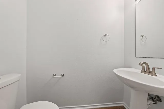 a bathroom with a sink mirror and toilet