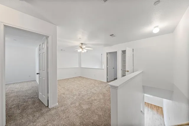 an empty room with chandelier fan