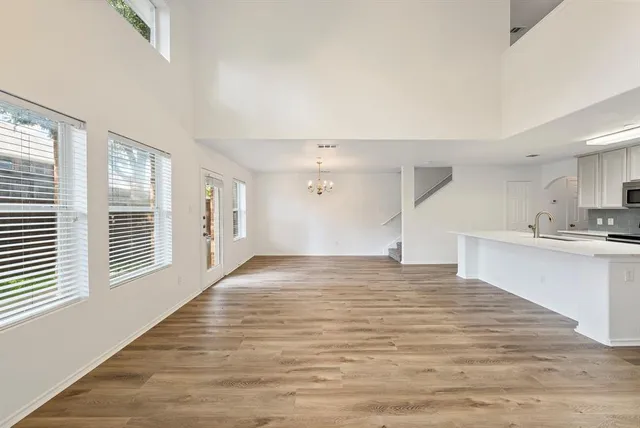 a view of a kitchen with kitchen island a sink wooden floor and a refrigerator