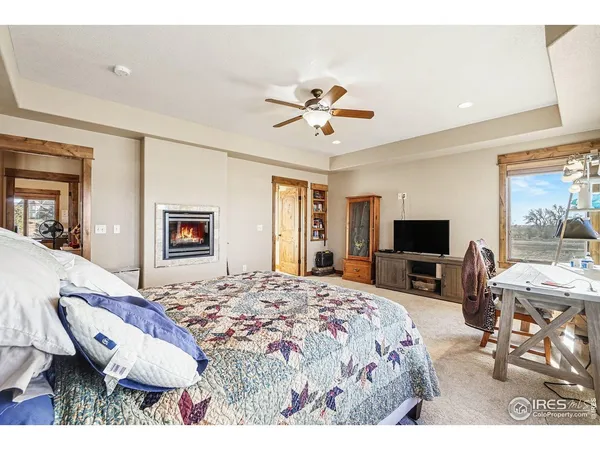 a bedroom with a bed a chair and a flat screen tv