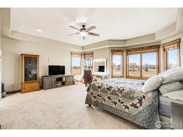 a bed room with a bed a television and dresser