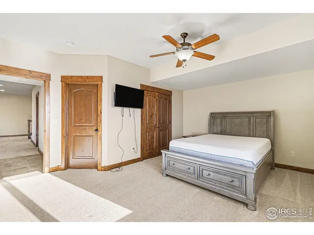 a spacious bedroom with a bed and a ceiling fan