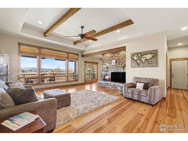 a living room with furniture flat screen tv and a large window