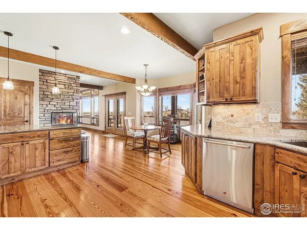 a open kitchen with granite countertop a stove top oven a sink with dining table and chairs