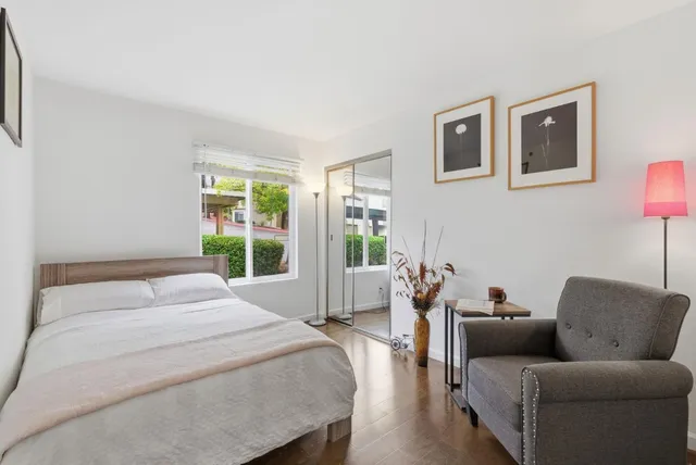 a bedroom with a bed couch and a large window