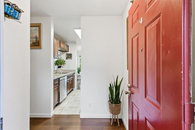 a kitchen with stainless steel appliances a counter top space and wooden floor