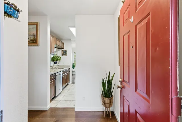 a kitchen with stainless steel appliances a counter top space and wooden floor