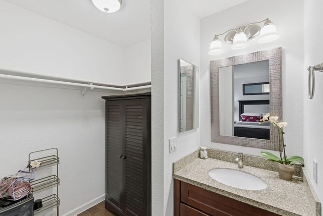 a bathroom with a granite countertop sink and a mirror