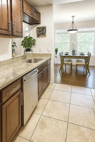 a kitchen with a sink a counter top space cabinets and a potted plant