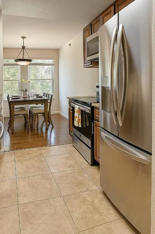 a kitchen with stainless steel appliances granite countertop a refrigerator and a stove top oven