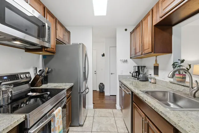 a kitchen with stainless steel appliances granite countertop a sink stove and refrigerator