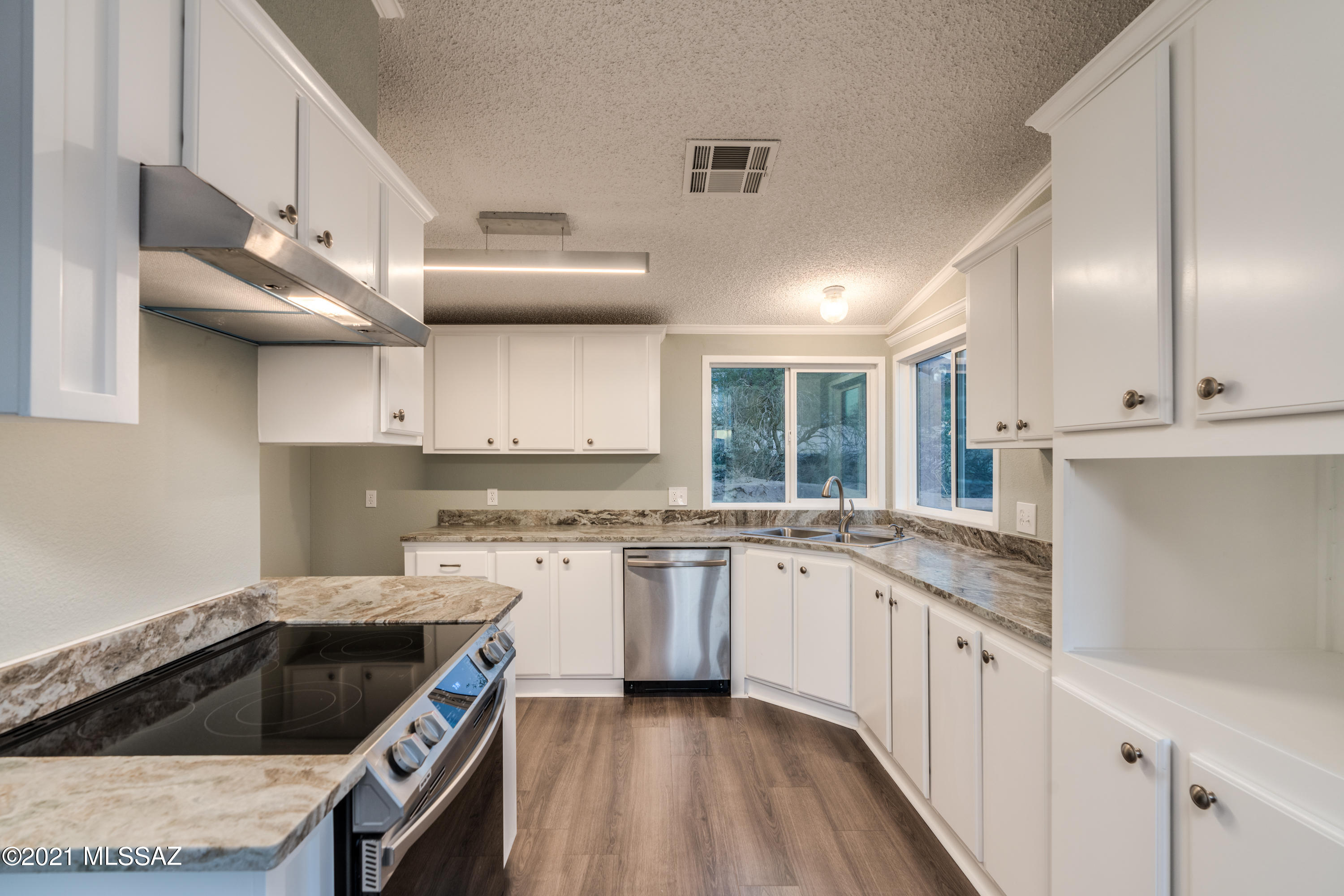 4489 East Wilds Road Tucson, AZ 85739 - Photo 19 of 50 a kitchen with granite countertop a sink a stove and cabinets