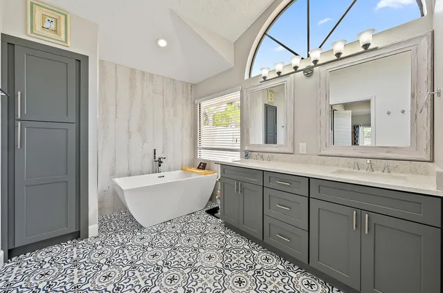 a bathroom with a double vanity sink mirror and bathtub