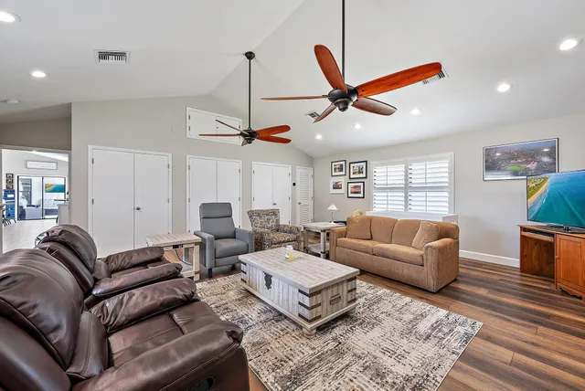 a living room with furniture a ceiling fan and a window