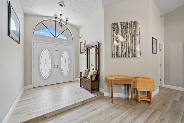 a view of a hallway with wooden floor and entryway