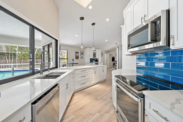 a kitchen with stainless steel appliances a sink stove and microwave