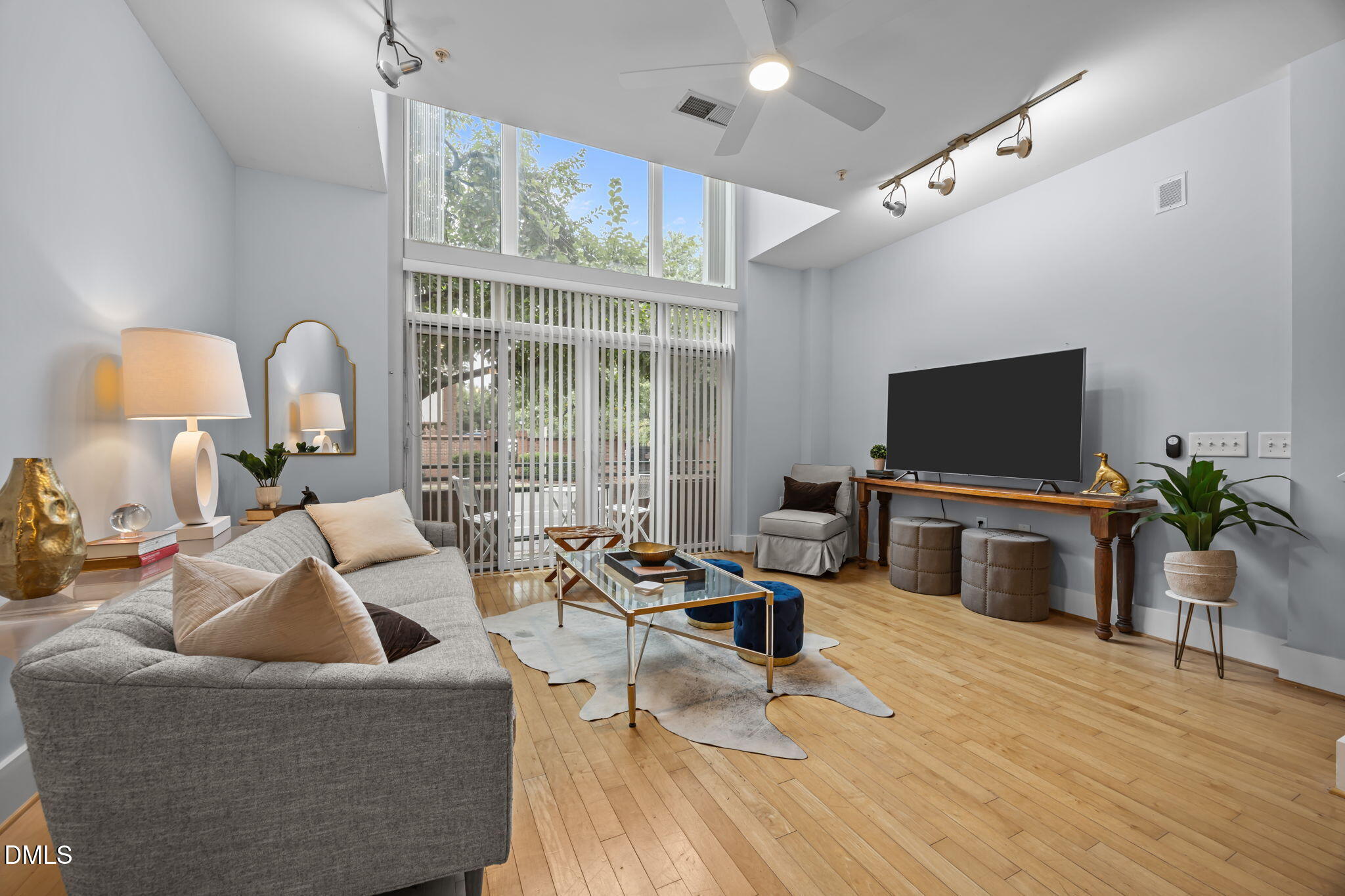 a living room with furniture flat screen tv and wooden floor