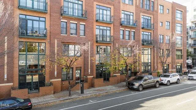 a view of a building and a cars park side of a street