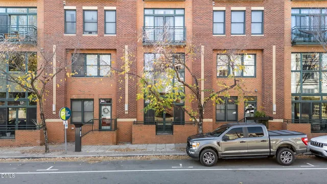 a view of a cars park in front of a building