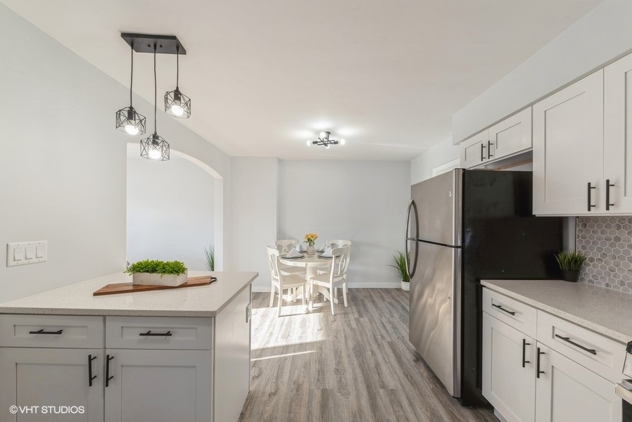 7250 West Rascher Avenue Chicago, IL 60656 - Photo 7 of 22 a kitchen with kitchen island white cabinets and stainless steel appliances