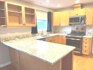 a kitchen with granite countertop sink and cabinets