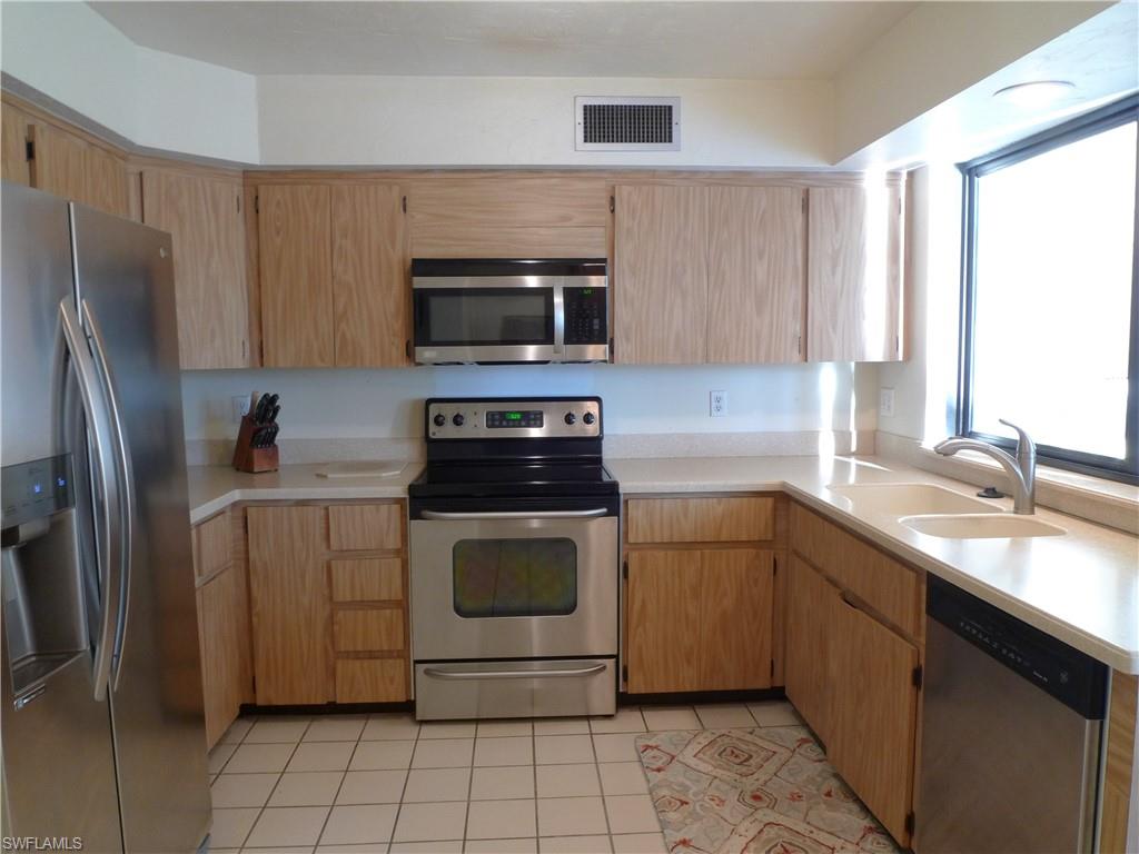 3115 Riviera Drive Naples, FL 34103 - Photo 6 of 15 KITCHEN WITH WINDOW PASS-THROUGH TO SECOND SOUTH-FACING LANAI