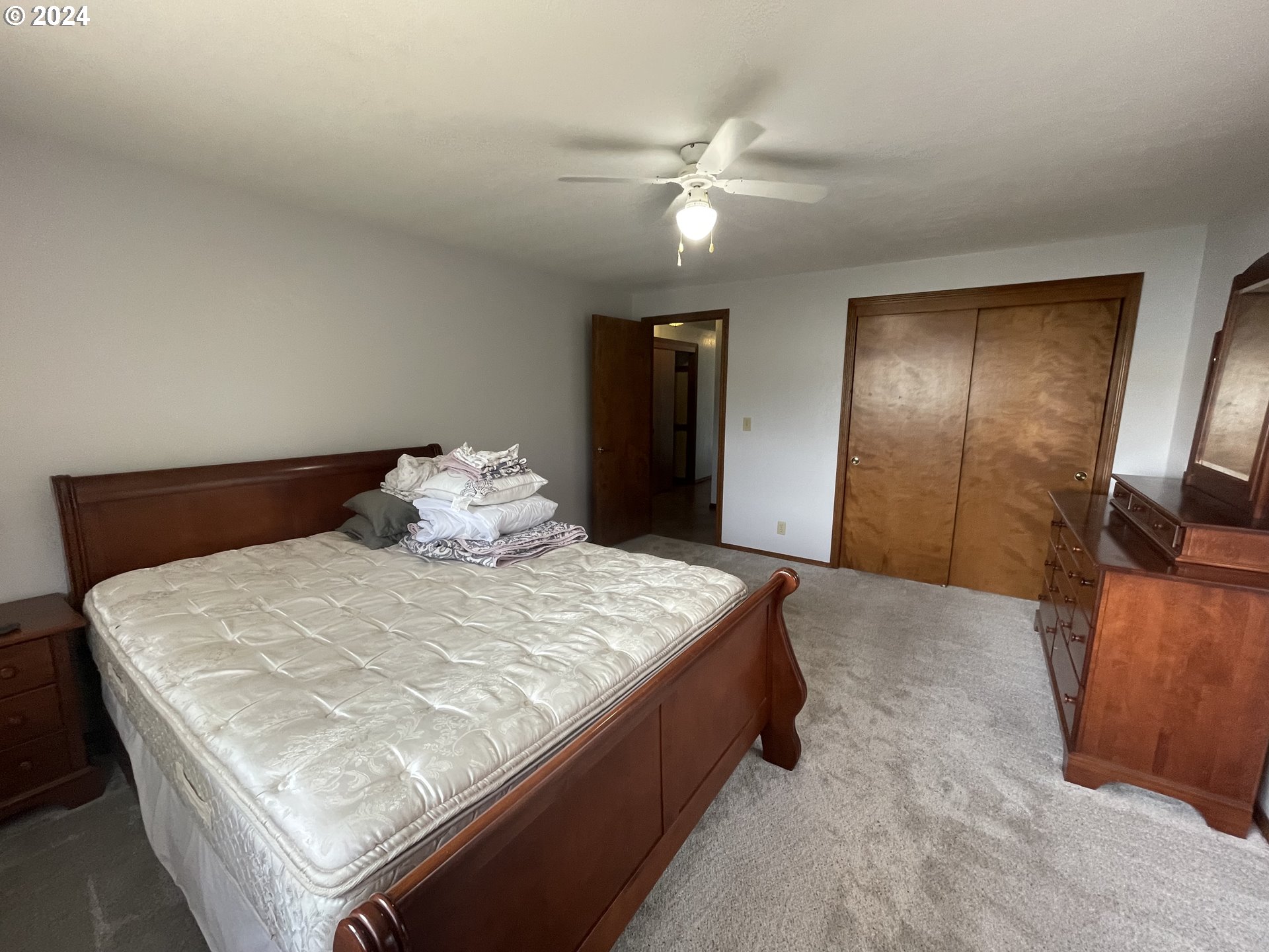 100 Rhododendron Drive Florence, OR 97439 - Photo 22 of 47 a bedroom with a bed and a chandelier