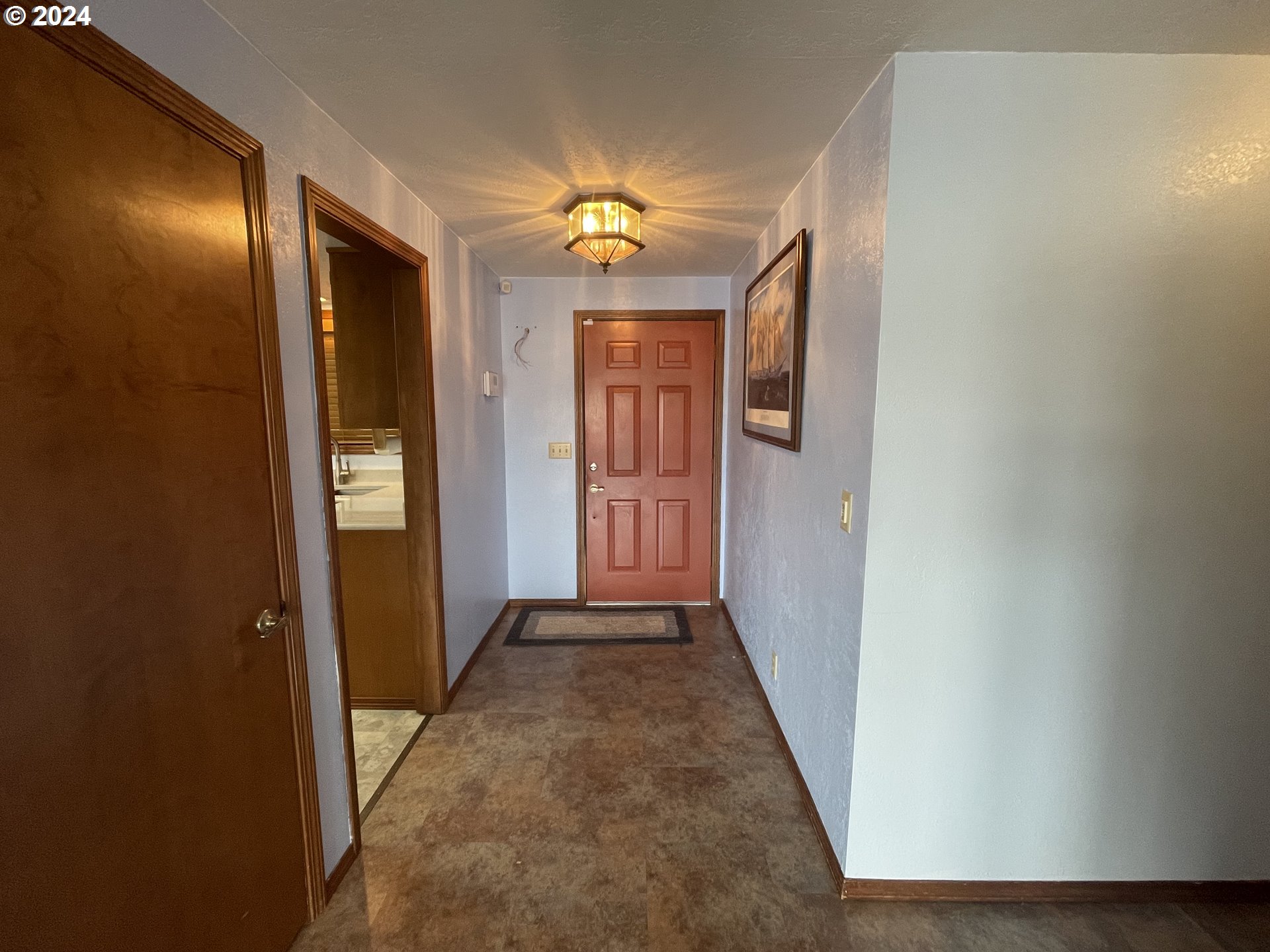 100 Rhododendron Drive Florence, OR 97439 - Photo 4 of 47 a view of a hallway with wooden floor and a bathroom