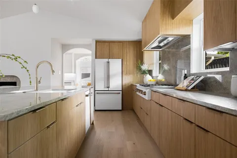 a kitchen with a sink a refrigerator and cabinets
