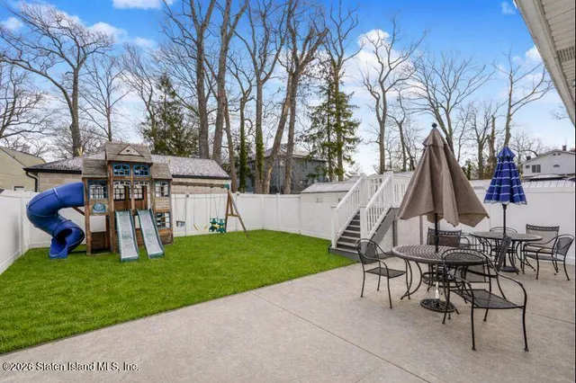 a view of a house with backyard and sitting area