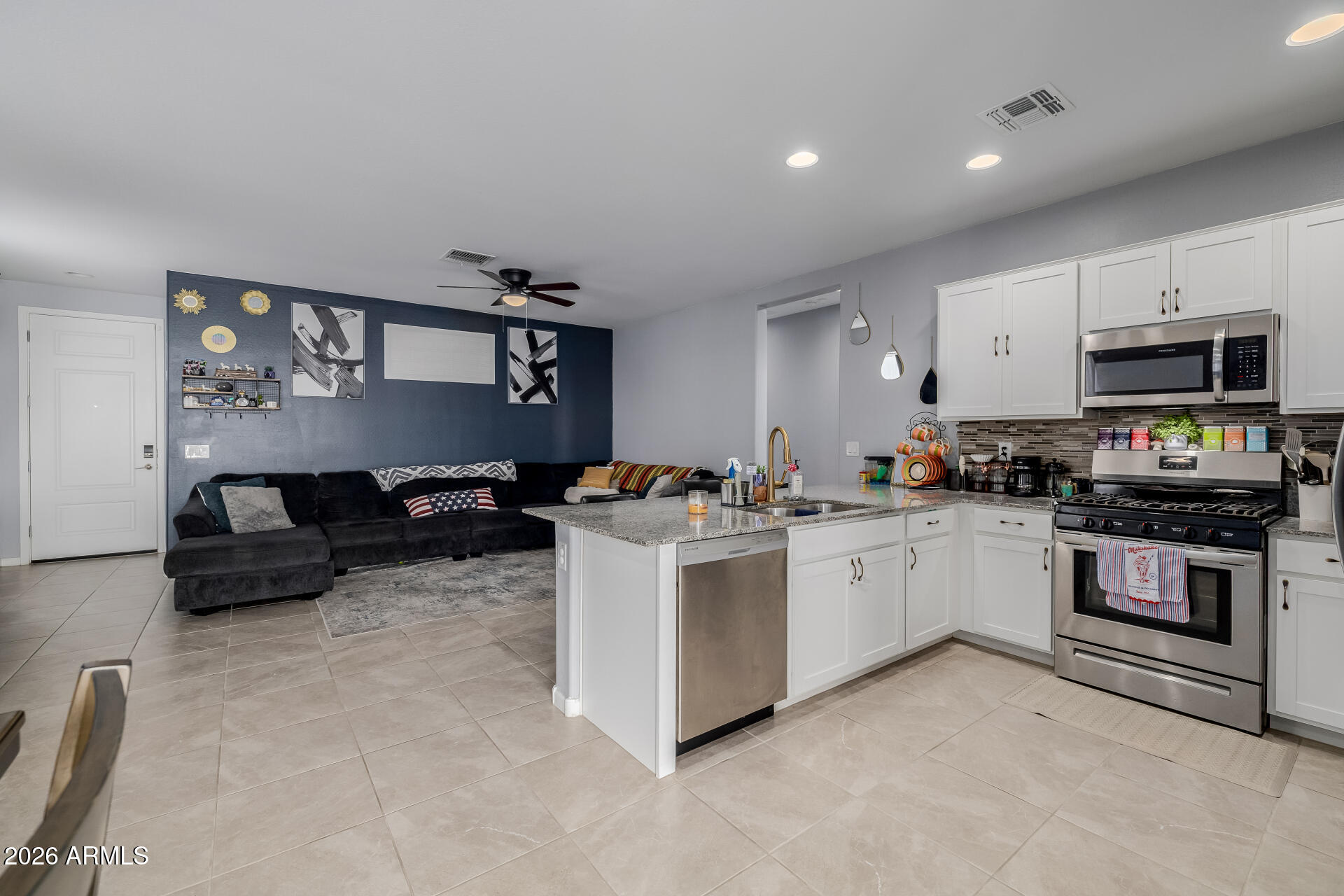10918 West Atlantis Way Tolleson, AZ 85353 - Photo 6 of 20 a kitchen with stainless steel appliances a stove a sink and a refrigerator