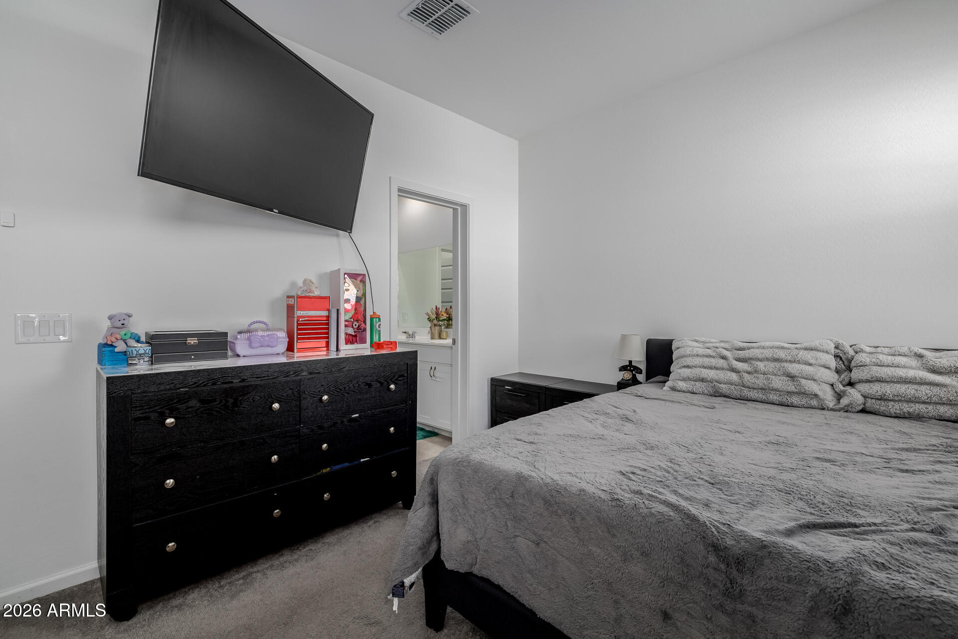 10918 West Atlantis Way Tolleson, AZ 85353 - Photo 10 of 20 a bedroom with a bed and a flat tv screen on dresser