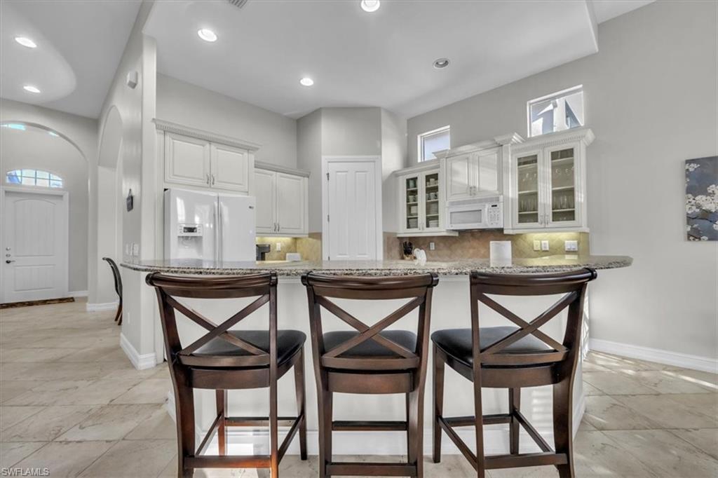 7793 Ashton Road Naples, FL 34113 - Photo 12 of 50 a view of a dining room with furniture and wooden floor