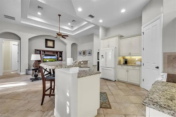 a kitchen with stainless steel appliances kitchen island granite countertop a refrigerator and microwave