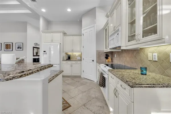 a kitchen with granite countertop a sink and cabinets