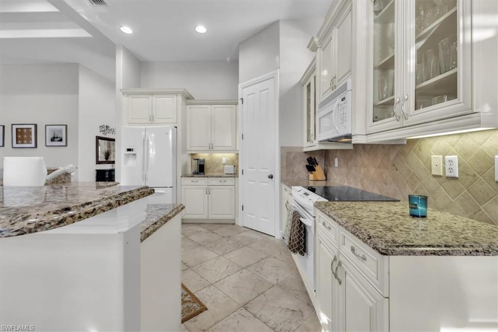 7793 Ashton Road Naples, FL 34113 - Photo 15 of 50 a kitchen with granite countertop a sink and cabinets