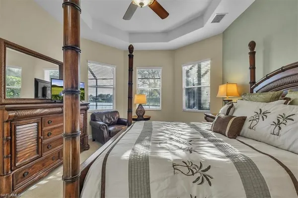 a bedroom with a bed couch tv and a window