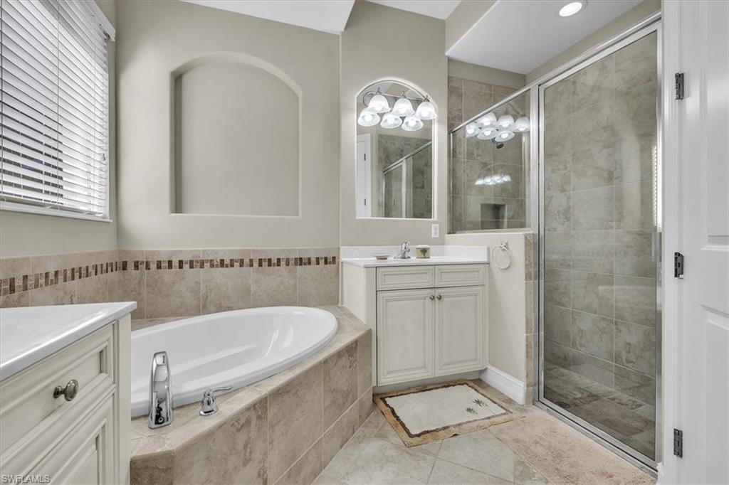 7793 Ashton Road Naples, FL 34113 - Photo 19 of 50 a bathroom with a tub a sink and a mirror