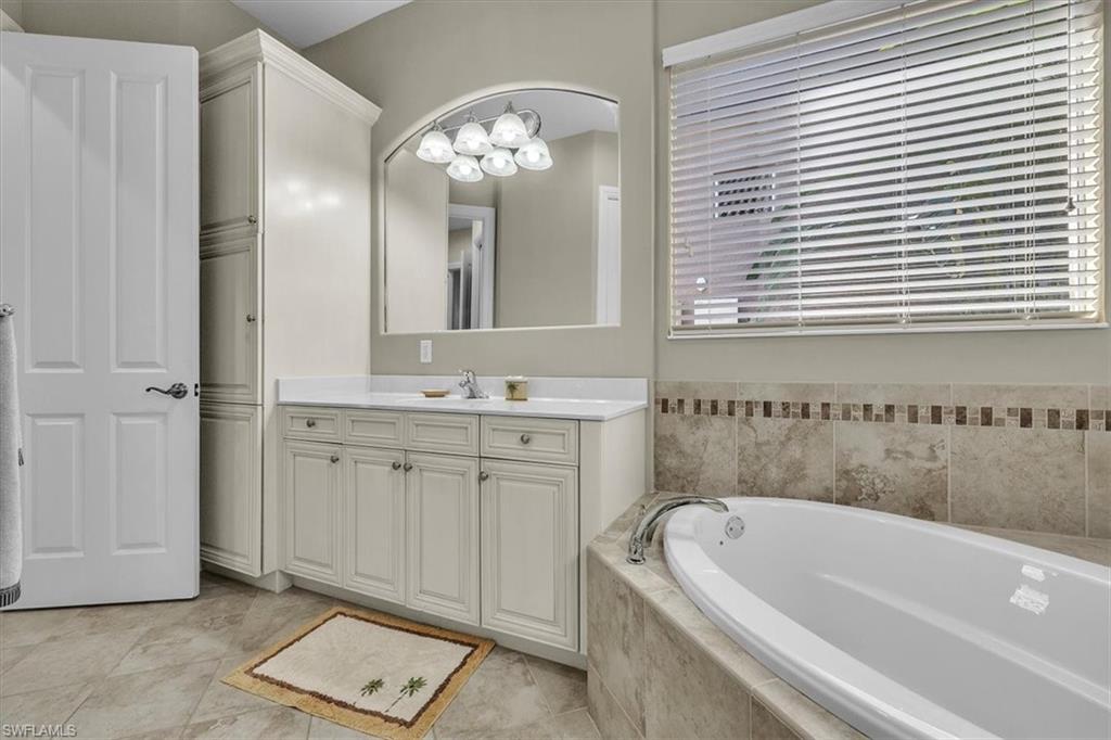 7793 Ashton Road Naples, FL 34113 - Photo 20 of 50 a bathroom with a tub a sink and a mirror