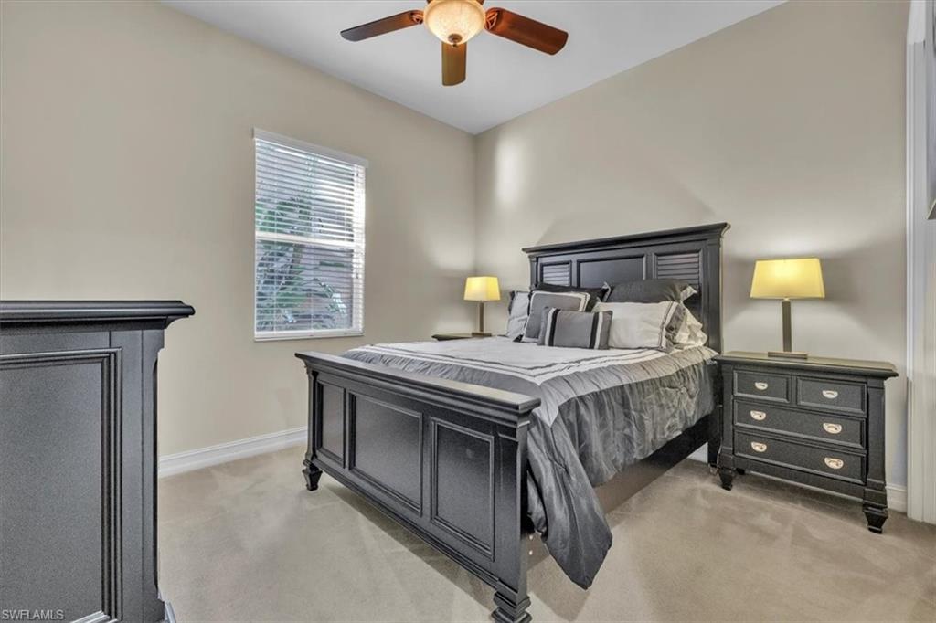 7793 Ashton Road Naples, FL 34113 - Photo 24 of 50 a bedroom with a bed and a chandelier