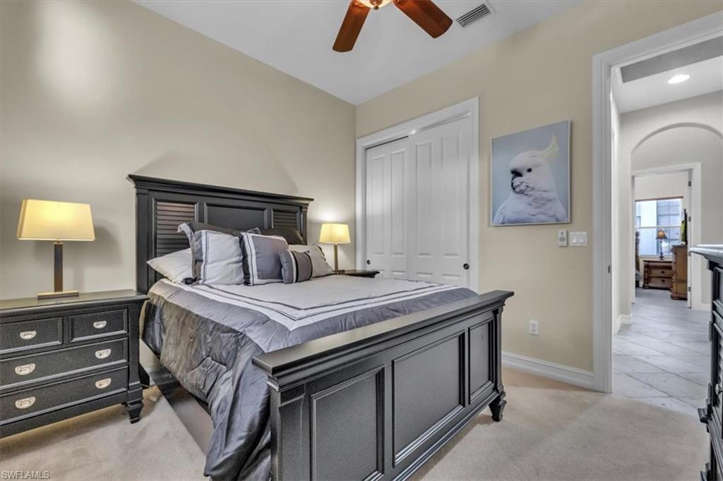 7793 Ashton Road Naples, FL 34113 - Photo 25 of 50 a bedroom with a bed and a chandelier