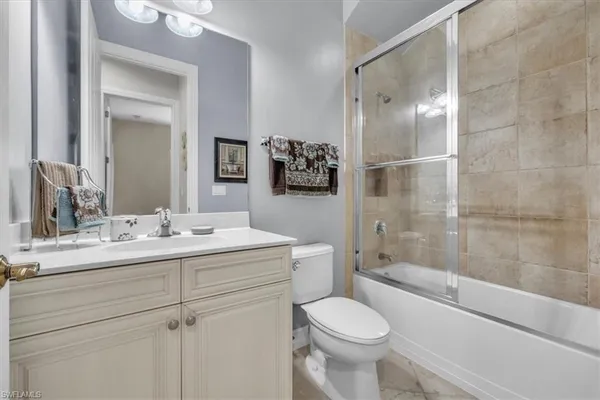 a bathroom with a sink vanity granite toilet and a mirror